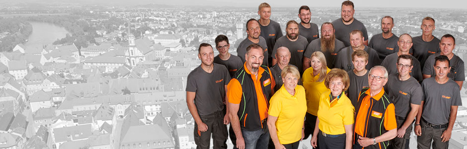 Das Team von Leutner + Gruber vor einer Ansicht von Straubing